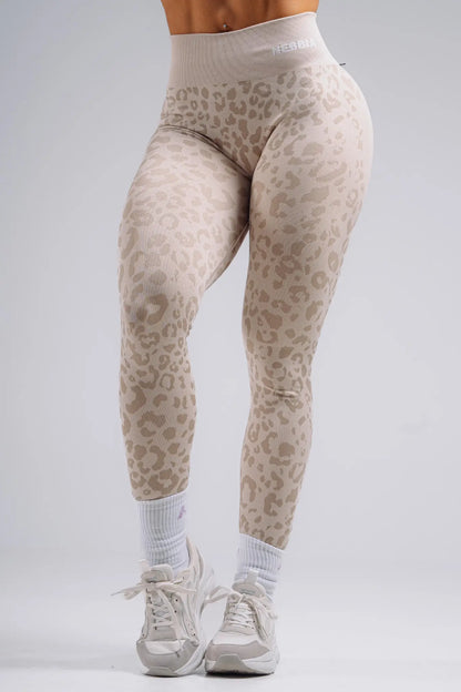 Beige leopard print leggings worn by a person on a gray background